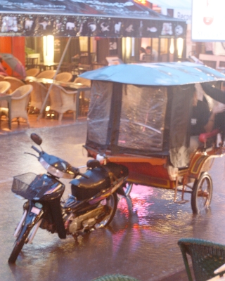 A tuk-tuk caught in torrential rain in Siem Reap's Pub Street