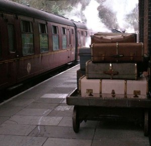 Luggage and a steam train in a station